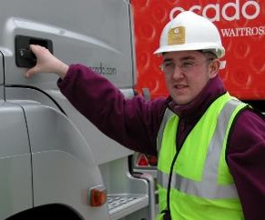 a_lorry_driver_wearing_a_hi-viz_big_and_a_white_hard_hat_about_to_climb_into_the_cab_of_a_HGV