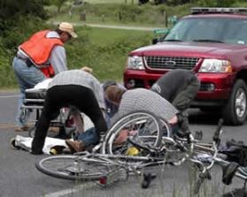 four_cyclists_tending_to_a_friend_lying_on_the_road__who_has_been_in_collision_with_a_red_SUV