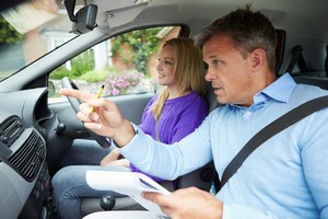 half day driving refresher course girl driving car with a defensive driving instructor pointing to give directions