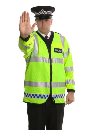 post driving ban course police officer in hi-viz jacket using his outstretched hand as a halt command