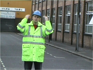 a banksman wearing a hi-viz jacket assisting a driver to reverse Banksman Training