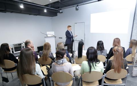 a group of delegates attending an advanced driving seminar & instructor with flip chart